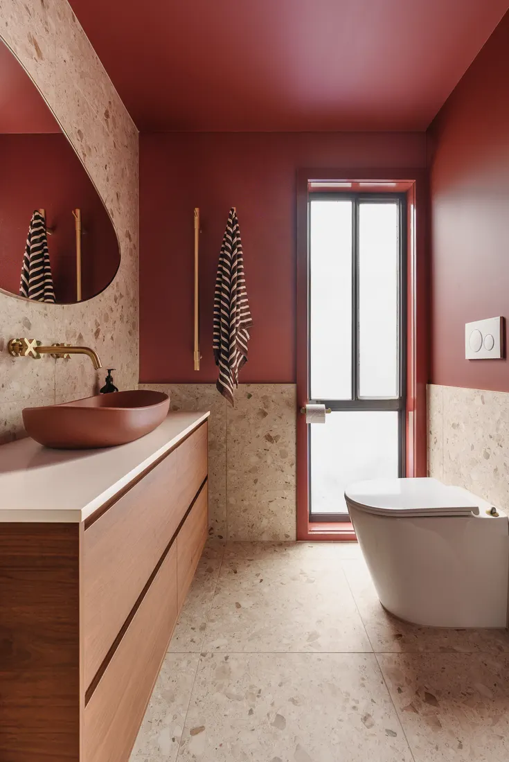 Terrazzo bathroom with wall-hung toilet and window by MNA Builds
