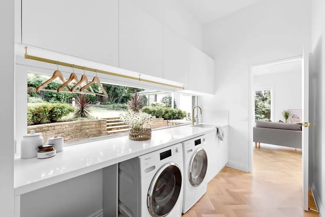Laundry with stone benchtop and garden window by MNA Builds