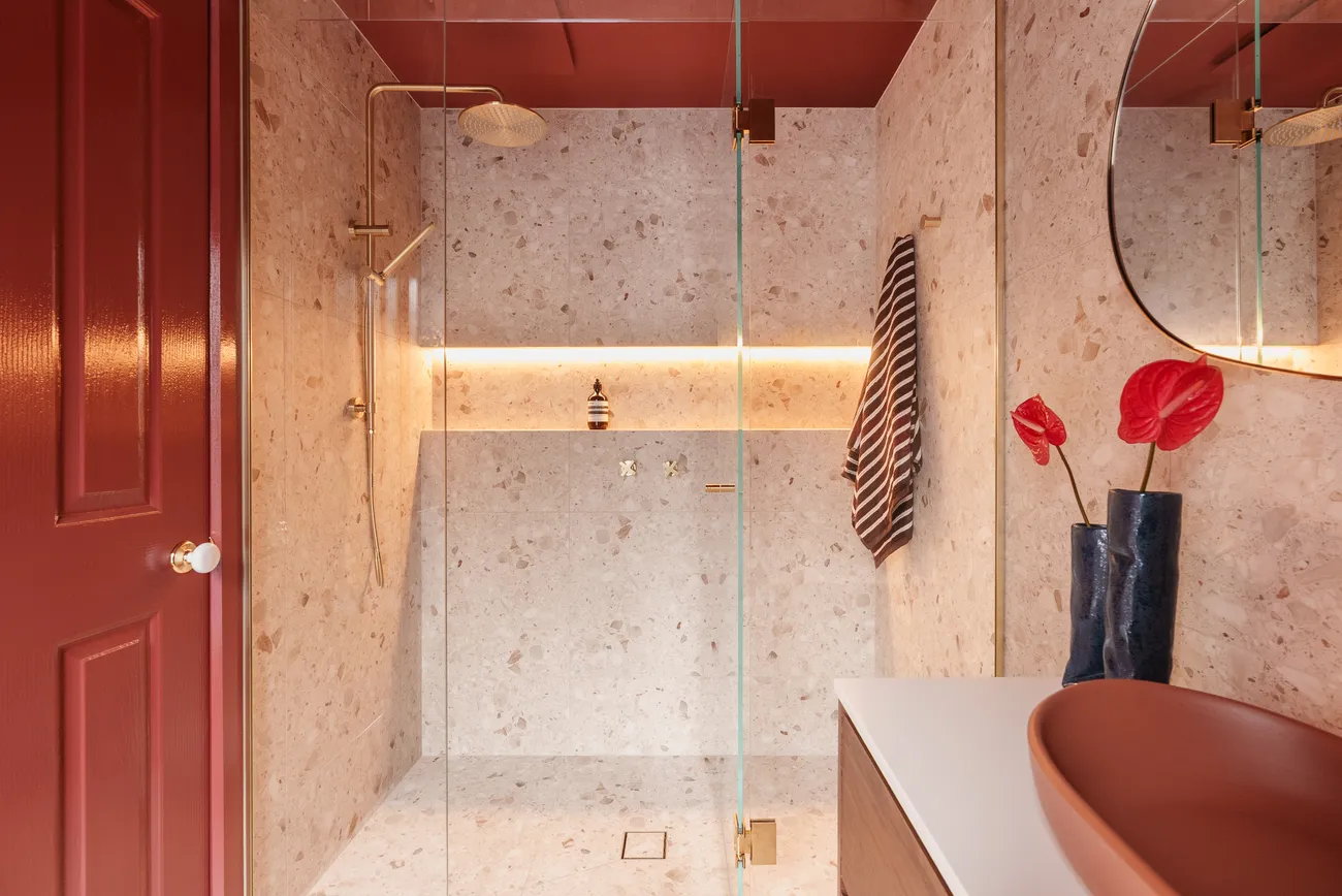 Waterproofed and tiled walk-in shower with terrazzo and brass fittings by MNA Builds